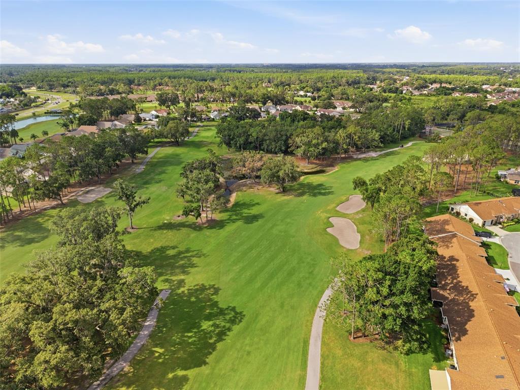 An aerial view of a golf course fairway lined with trees and residential buildings — 6525 PINE WALK DRIVE, NEW PORT RICHEY, FL