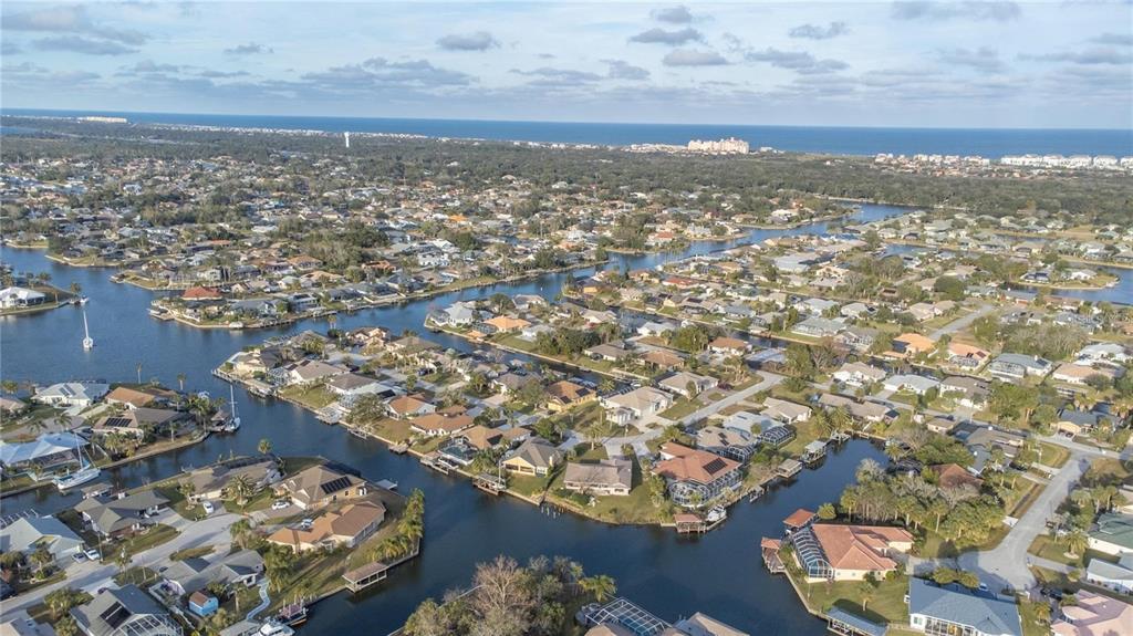 An aerial view of a residential neighborhood featuring waterfront homes along a network of canals — 8 COLLINGVILLE COURT, PALM COAST, FL