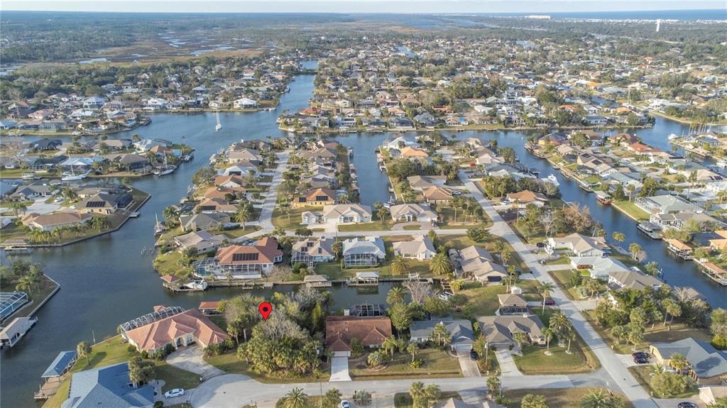 An aerial view shows a residential neighborhood with houses situated along interconnected canals — 8 COLLINGVILLE COURT, PALM COAST, FL