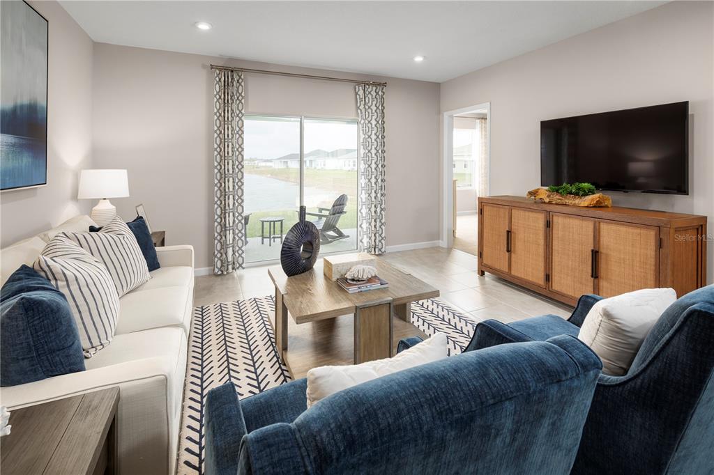 A living room features a sofa, two blue armchairs, a wooden coffee table, and a television — 1259 TURTLE ISLAND ROAD, LADY LAKE, FL