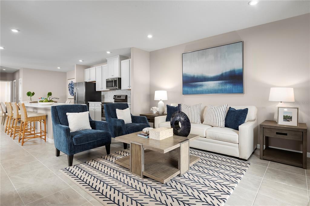 A living room with blue armchairs and a white sofa sits adjacent to a kitchen — 1259 TURTLE ISLAND ROAD, LADY LAKE, FL