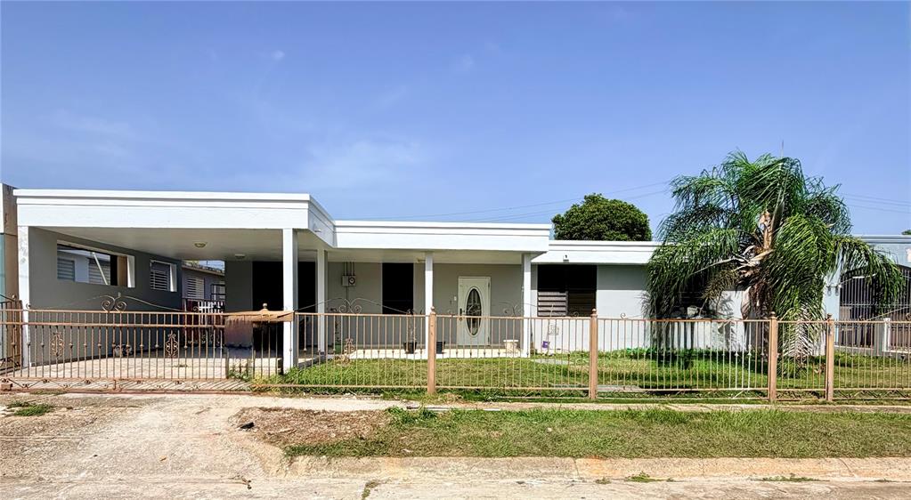 A single-story house with a flat roof, a carport, and a metal fence in front — #131 CALLE HARRINSON BASE RAMEY, AGUADILLA, PR