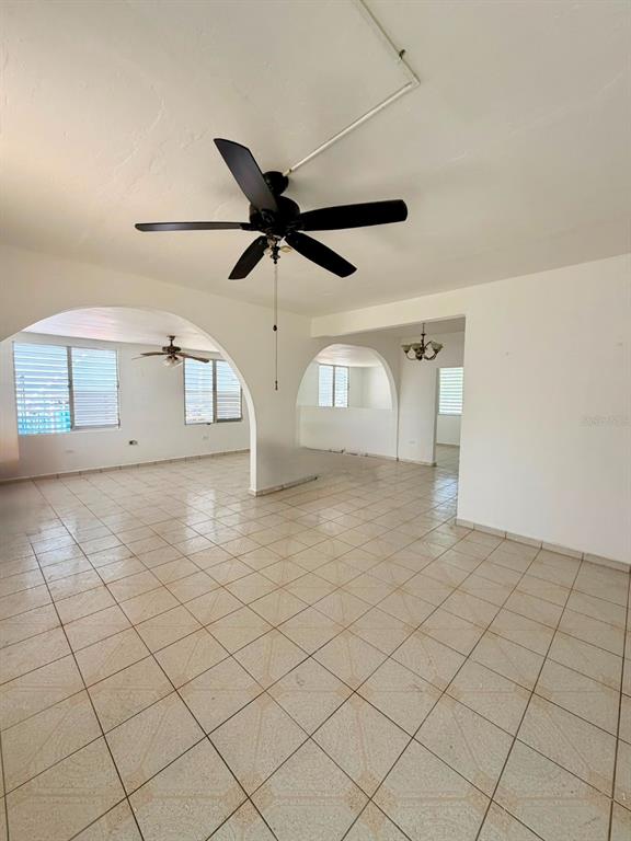 An open-concept living area features white walls, tiled floors, and two ceiling fans — #131 CALLE HARRINSON BASE RAMEY, AGUADILLA, PR