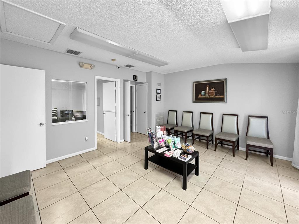 A waiting room features light tile flooring, gray walls, five chairs, and a coffee table — 5438 TROUBLE CREEK ROAD, NEW PORT RICHEY, FL