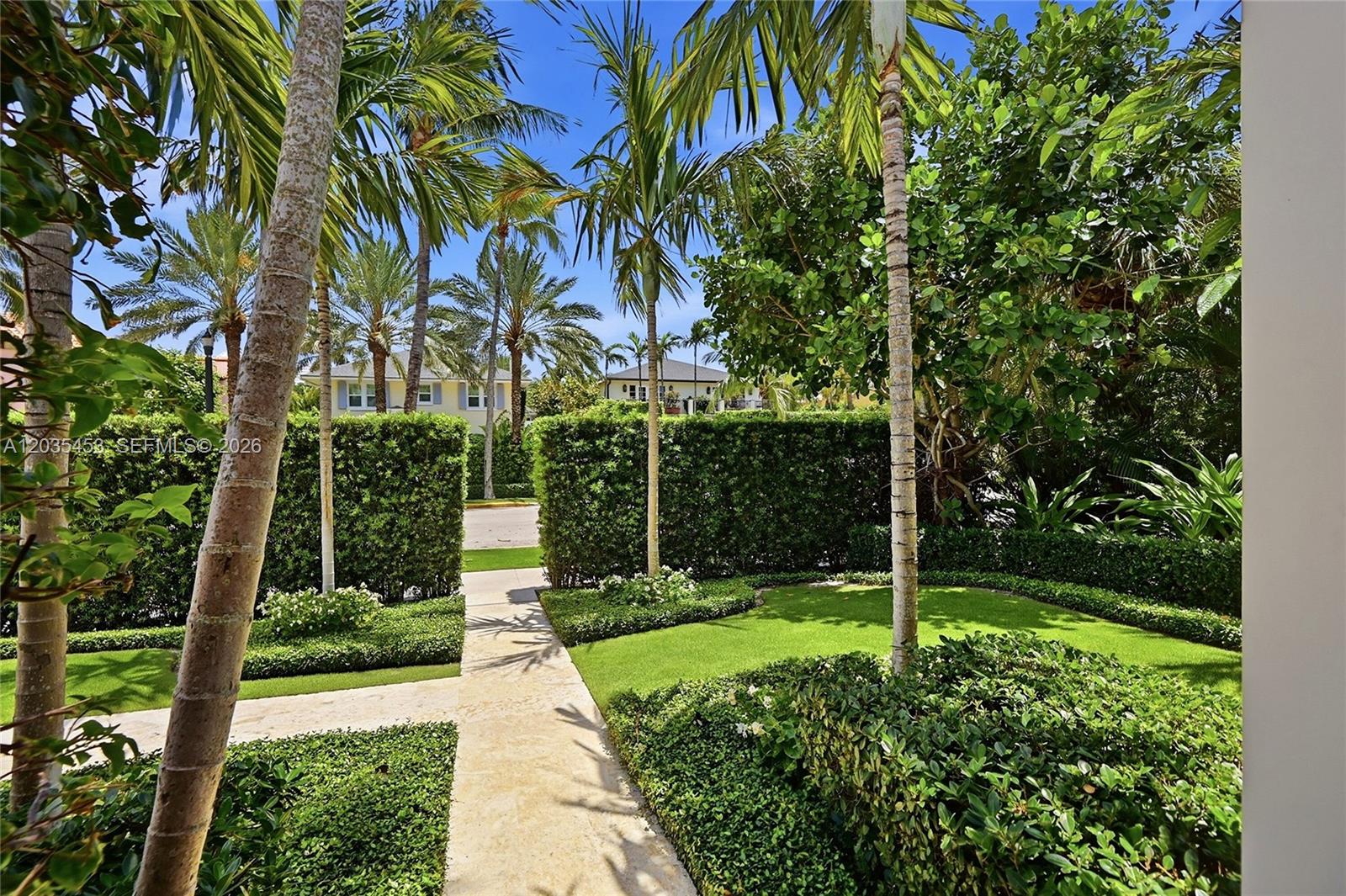 A stone walkway leads through a manicured lawn and hedges toward a residential street — 135 Chilean Ave, Palm Beach FL 33480, PALM BEACH, FL