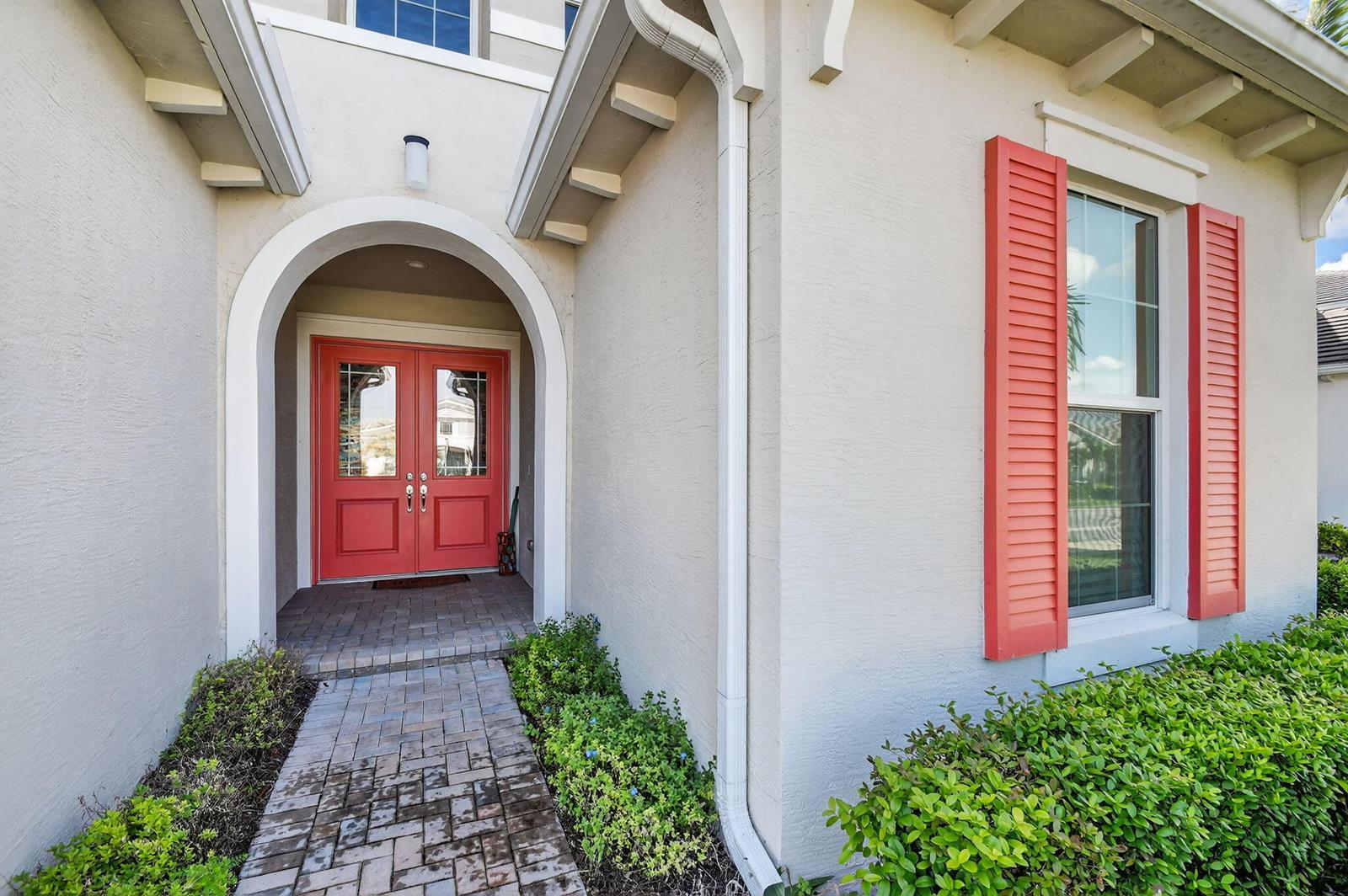 A house entrance features a red double door, arched entryway, and red window shutters — 5632 Liberty Lane, Westlake FL 33470, WESTLAKE, FL