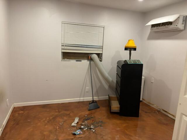 A room with a stained concrete floor, a window with a vent hose, and a dresser — 360 Leisure Boulevard, Pompano Beach FL 33064, POMPANO BEACH, FL