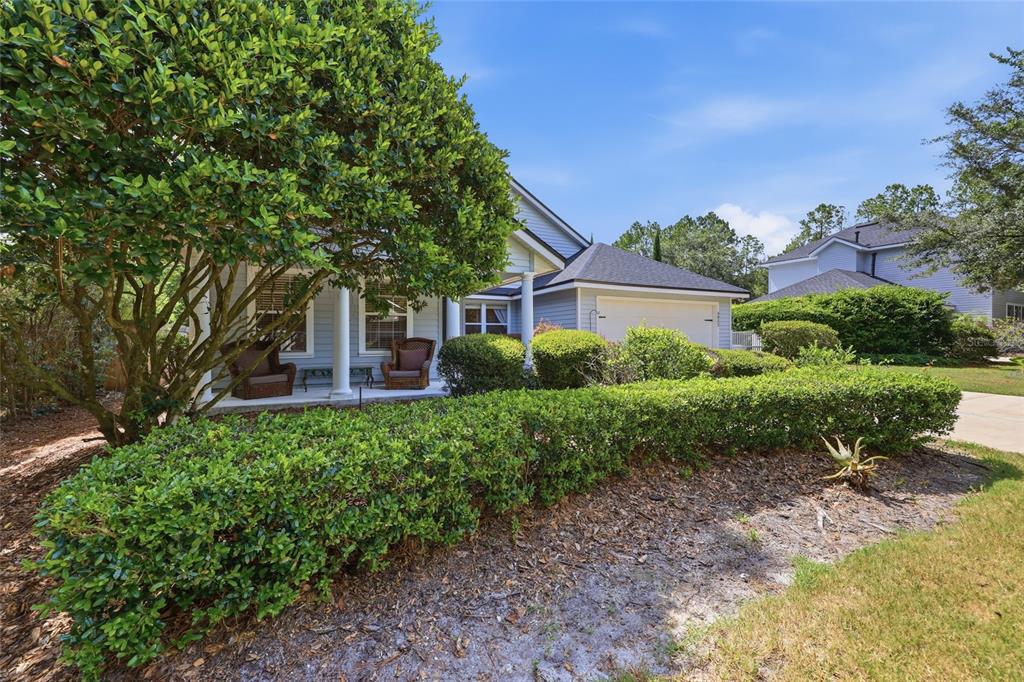 A single-story house with a front porch, a garage, and manicured hedges in the yard — 3052 SW 94TH STREET, GAINESVILLE, FL