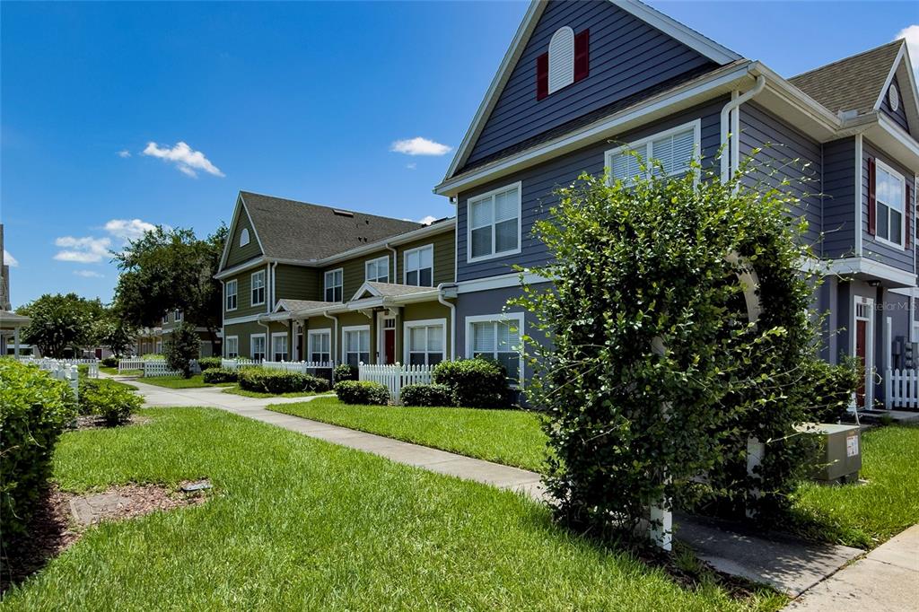 A multi-story residential building with blue and green siding and white picket fences — 2616 LODI CIRCLE UNIT 104, KISSIMMEE, FL