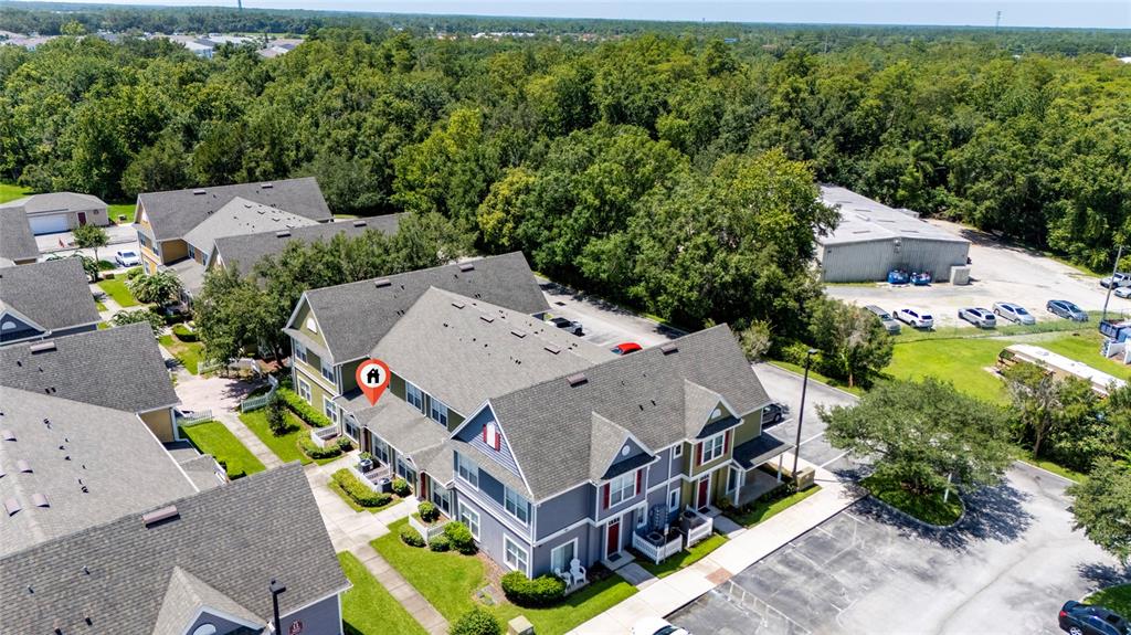 An aerial view shows a multi-story residential building with gray siding and a shingled roof — 2616 LODI CIRCLE UNIT 104, KISSIMMEE, FL