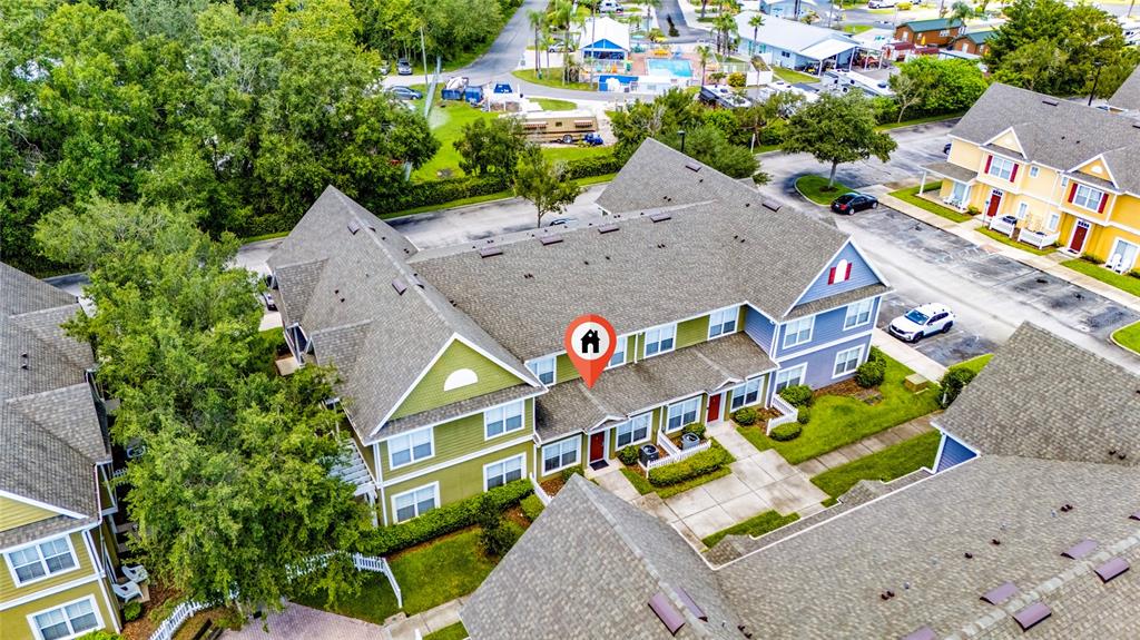 An aerial view shows a multi-story residential building with green and blue siding — 2616 LODI CIRCLE UNIT 104, KISSIMMEE, FL