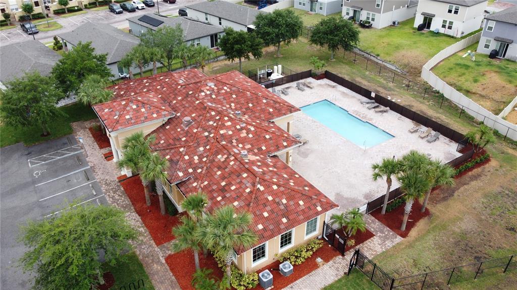 An aerial view shows a community clubhouse with a red tile roof and swimming pool — 2380 BELLA VISTA DRIVE, DAVENPORT, FL