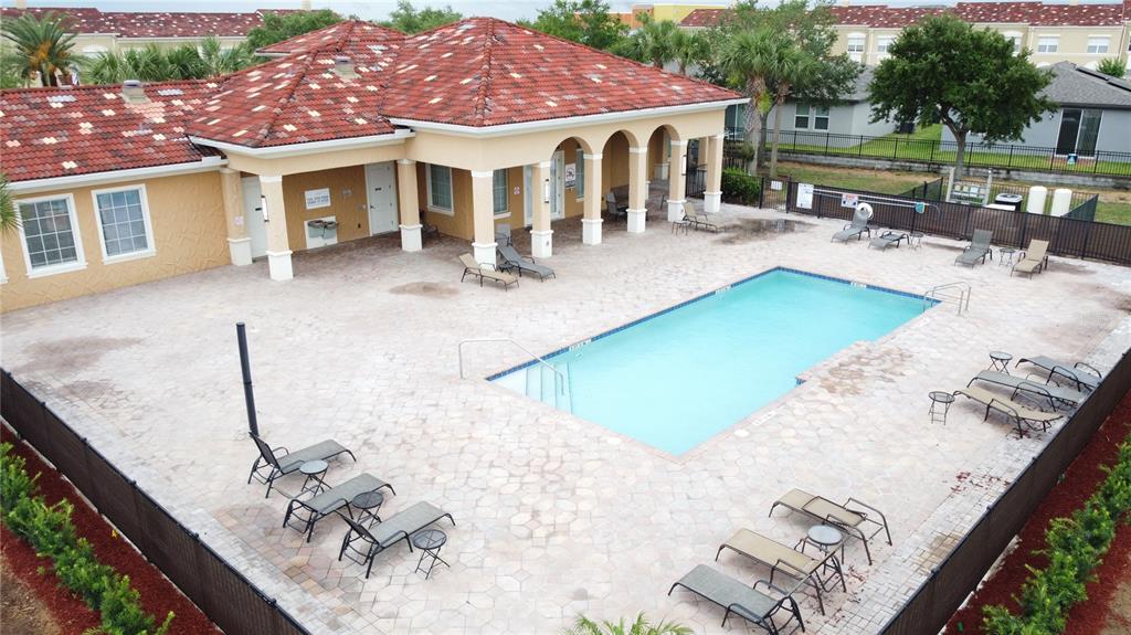 An aerial view of a swimming pool with lounge chairs on a paved patio deck — 2380 BELLA VISTA DRIVE, DAVENPORT, FL