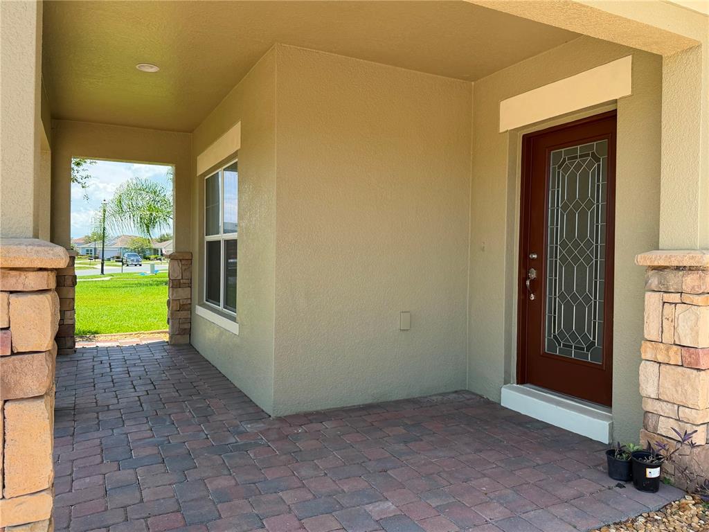 A two-story suburban house with a tan stucco exterior, stone accents, and a paved driveway — 3437 BRANT STREET, ST CLOUD, FL