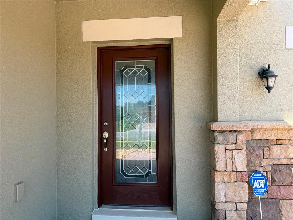 A two-story suburban house with a stone-accented facade, a three-car garage, and a paved driveway — 3437 BRANT STREET, ST CLOUD, FL