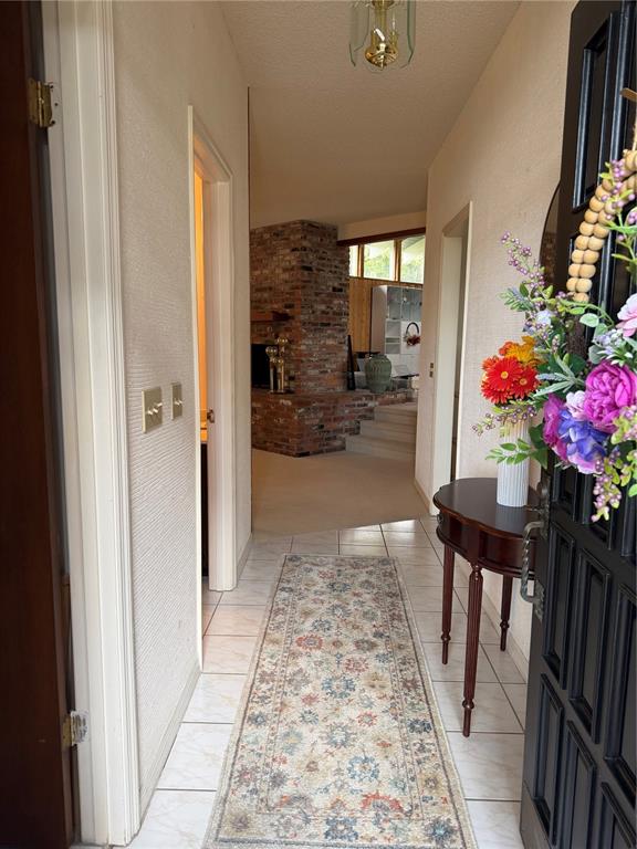 An entryway with a tiled floor, a runner rug, and a view of a brick fireplace — 924 RIDGECREST ROAD, ORLANDO, FL