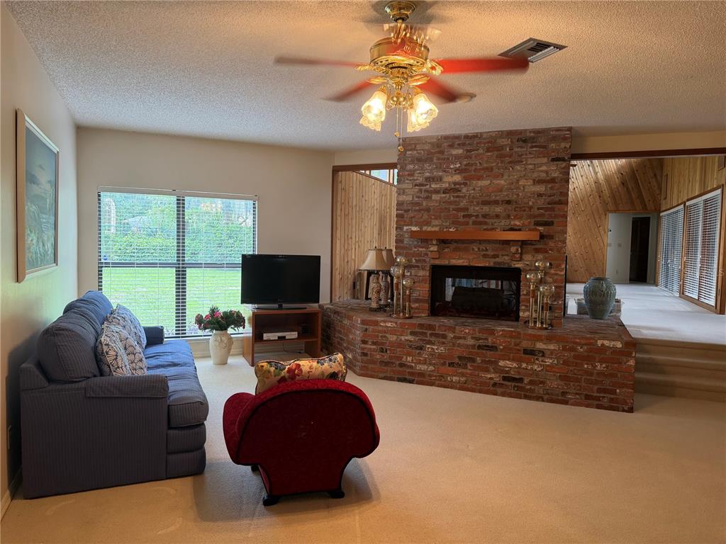 A living room features a brick fireplace, a blue sofa, a red chair, and carpet — 924 RIDGECREST ROAD, ORLANDO, FL