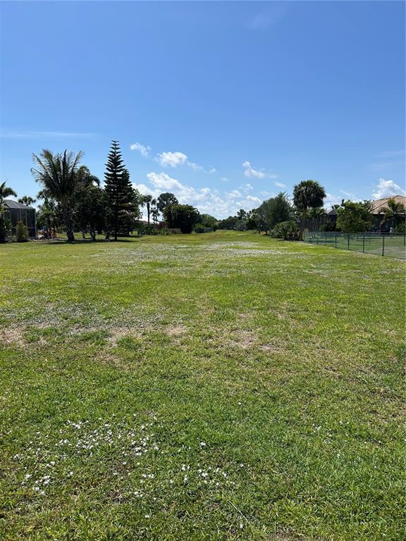 A large, flat, grassy vacant lot under a clear blue sky — 7357 PARKINSONIA, PUNTA GORDA, FL