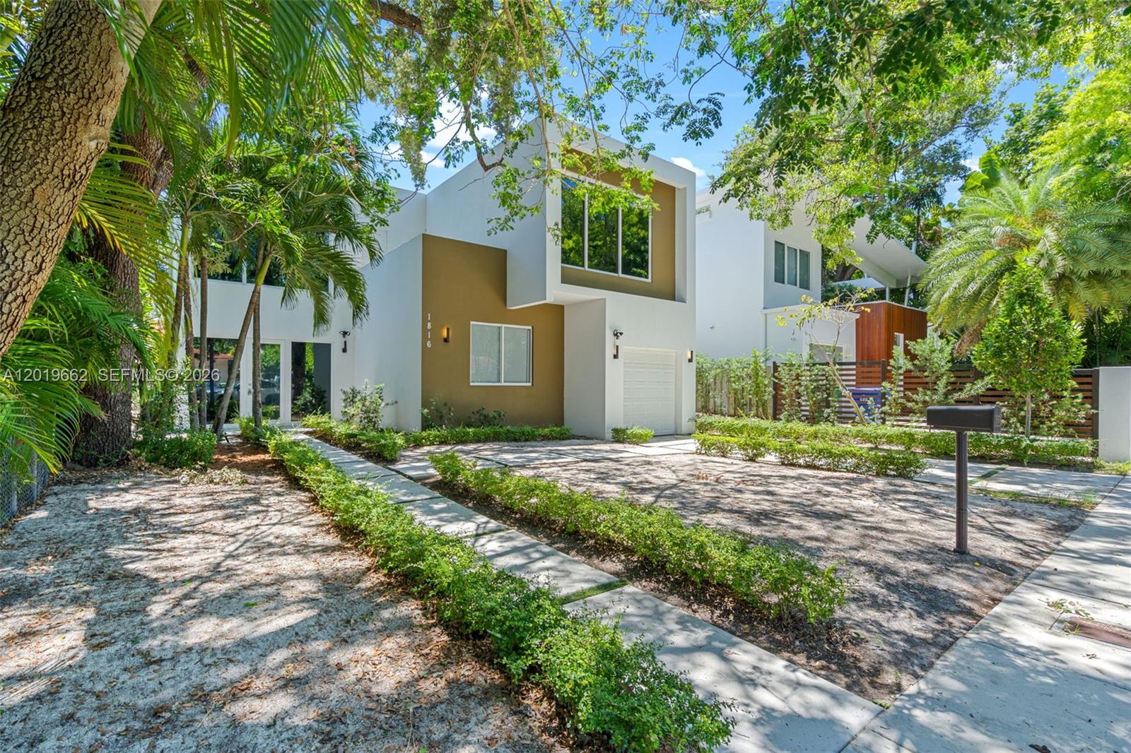A modern two-story house with a white and brown facade sits behind a landscaped driveway — 1816 SW 23rd St, Miami FL 33145, MIAMI, FL