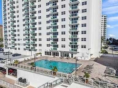 An exterior view of a high-rise apartment building with a swimming pool and parking area — 3000 S Ocean Dr # 420, Hollywood FL 33019, HOLLYWOOD, FL