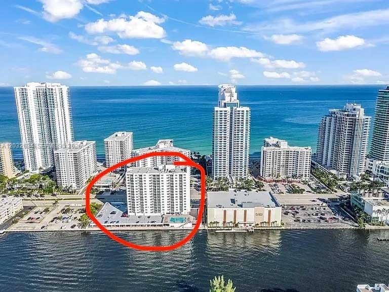 An aerial view of a mid-rise residential building situated between a parking lot and water — 3000 S Ocean Dr # 420, Hollywood FL 33019, HOLLYWOOD, FL