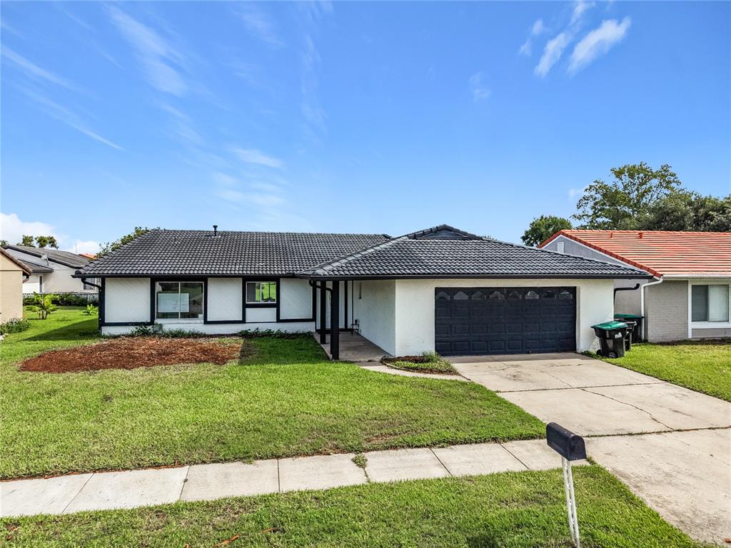 A single-story house with a white exterior, black trim, and a dark tiled roof — 5501 MEMORIAL DRIVE, ORLANDO, FL
