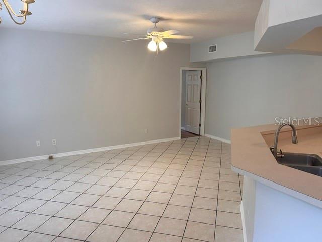A room with light-colored tile flooring, a ceiling fan, and a kitchen counter — 350 NW 50 BOULEVARD UNIT 350, GAINESVILLE, FL