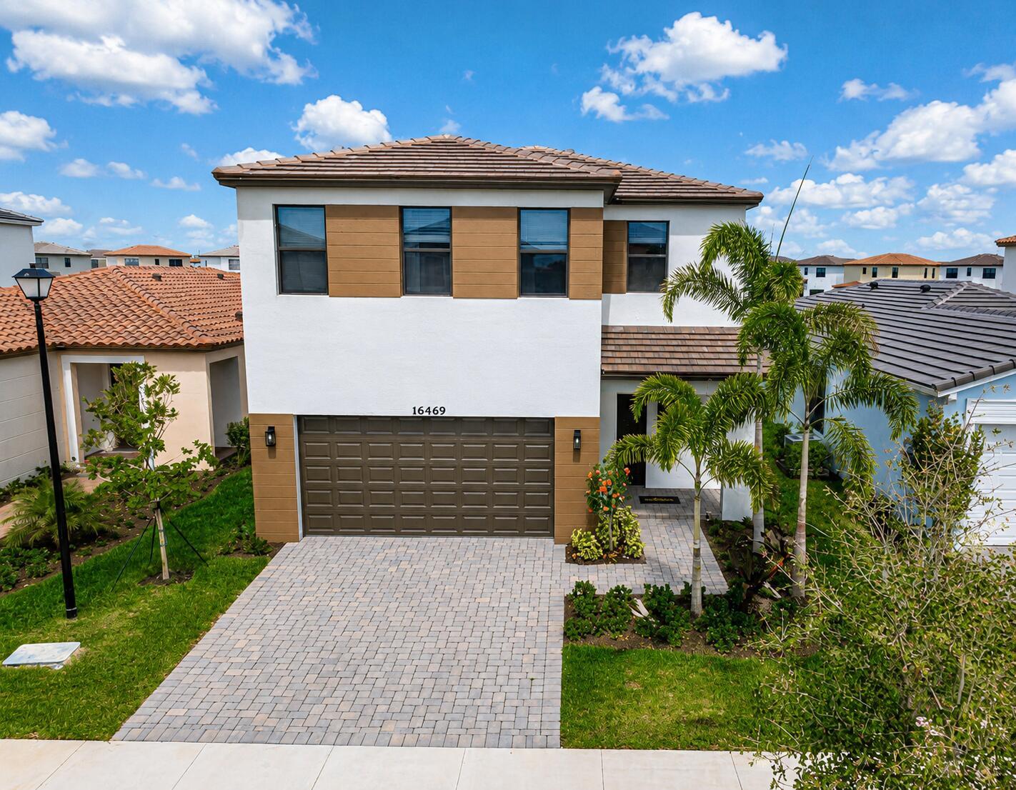 A two-story house with a brown garage, white stucco walls, and a paved driveway — 16469 Sea Turtle Place, Westlake FL 33470, WESTLAKE, FL