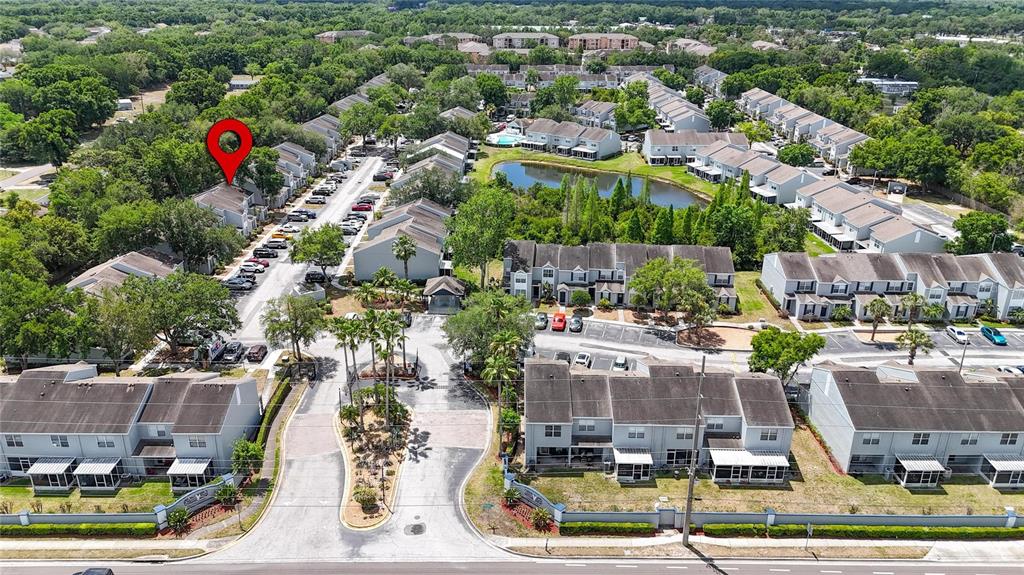 An aerial view shows a residential complex with multiple townhome buildings, a pond, and parking — 6557 OSPREY LAKE CIRCLE, RIVERVIEW, FL