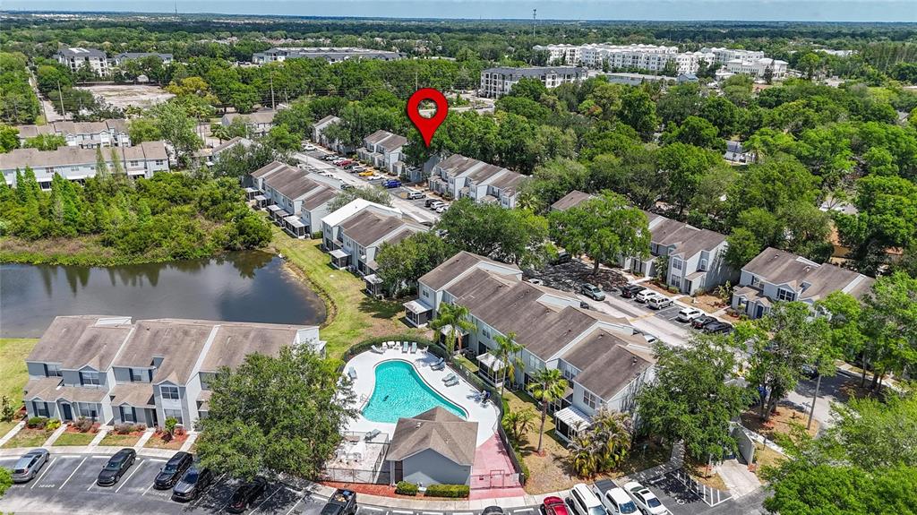 This aerial view shows a residential townhouse complex with a swimming pool and parking area — 6557 OSPREY LAKE CIRCLE, RIVERVIEW, FL