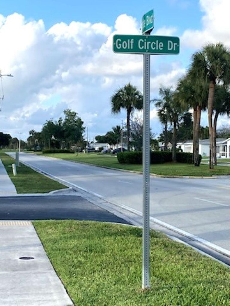 A street sign for Golf Circle Drive stands on a grassy corner near a road — 7817 Golf Cir Drive # 210, Margate FL 33063, MARGATE, FL