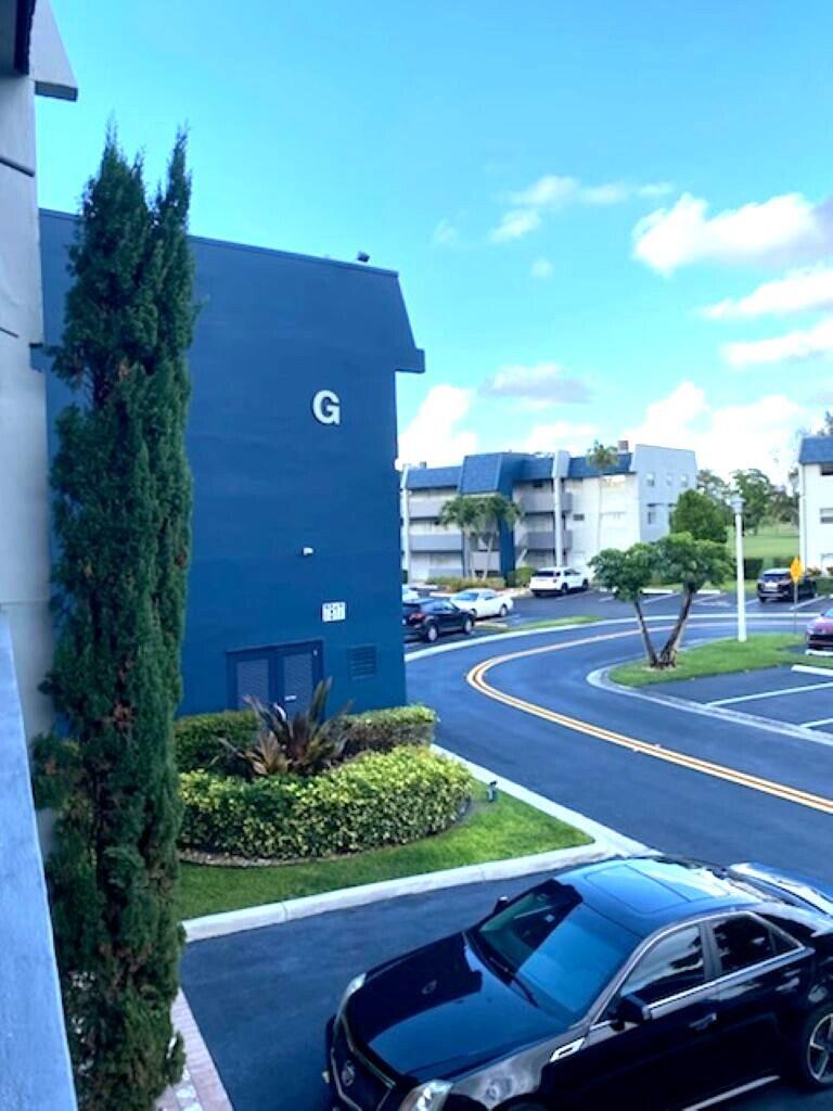 An exterior view of a blue apartment building marked with a large letter G — 7817 Golf Cir Drive # 210, Margate FL 33063, MARGATE, FL