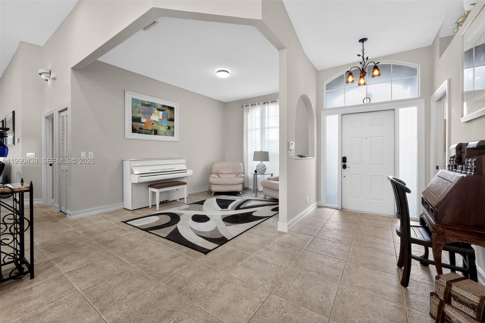 An entryway leads into a living area featuring a white piano and tiled flooring — 12301 Cabot Ct, Boca Raton FL 33428, BOCA RATON, FL
