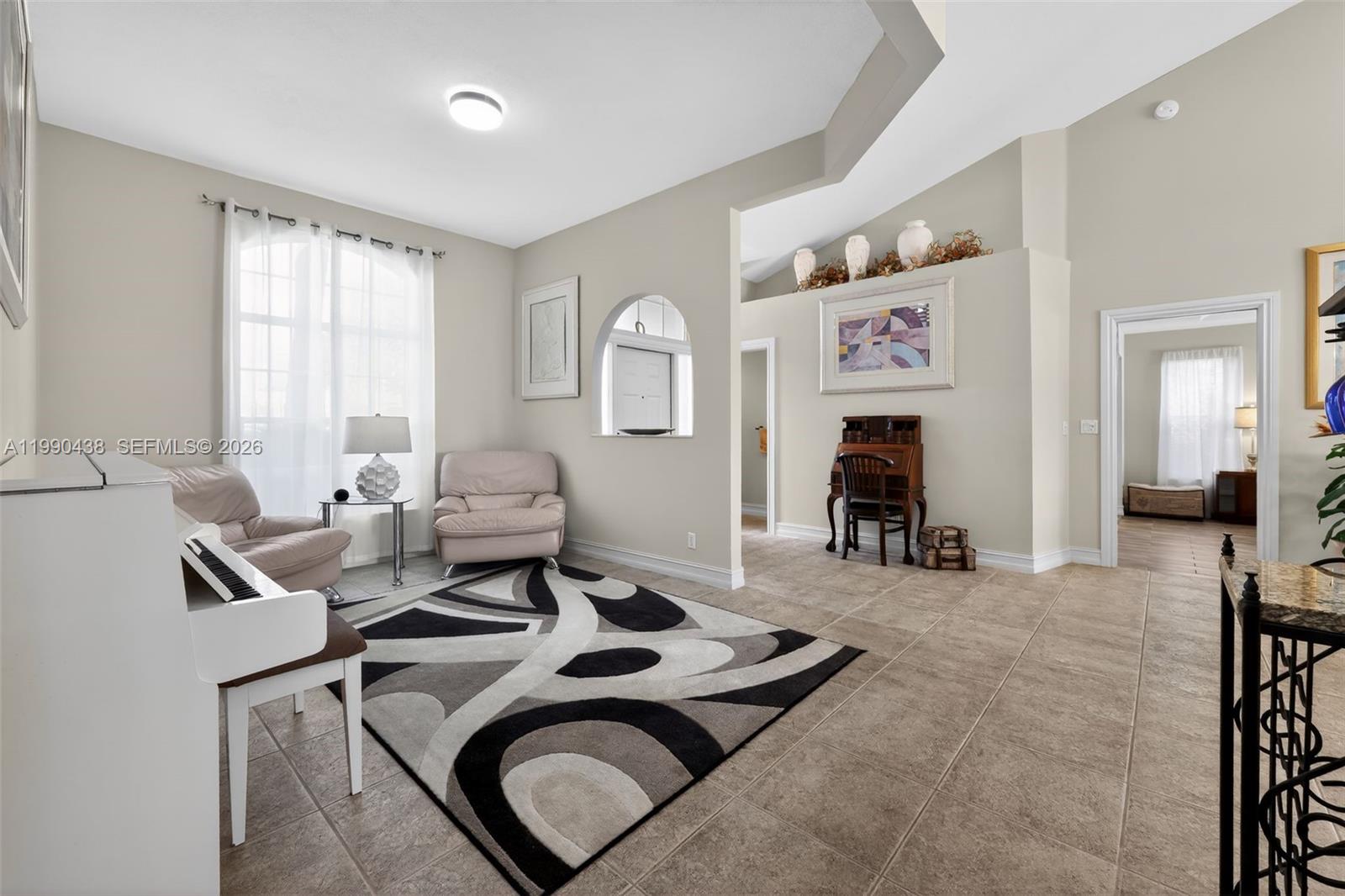 A living room features tile flooring, a white piano, two armchairs, and an area rug — 12301 Cabot Ct, Boca Raton FL 33428, BOCA RATON, FL