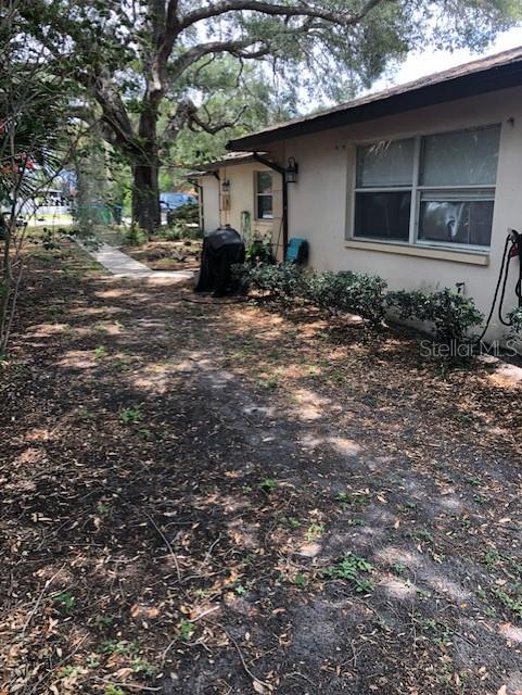 The exterior of a house features a tan wall, a window, and a small garden — 10876 72ND AVENUE UNIT C, SEMINOLE, FL