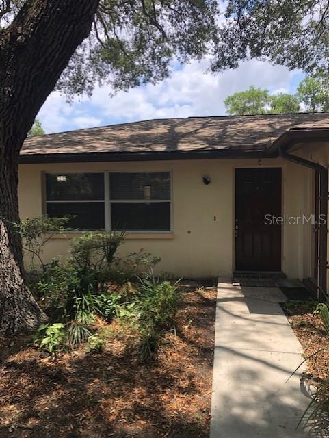 A single-story building exterior features a dark front door, a window, and a concrete walkway — 10876 72ND AVENUE UNIT C, SEMINOLE, FL