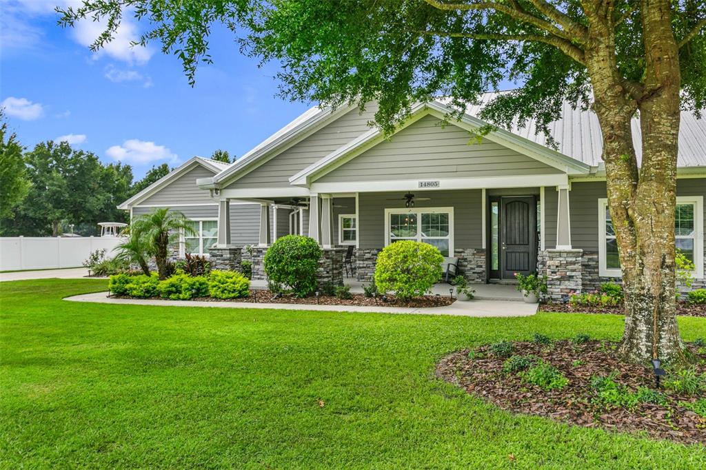 A gray house with stone accents, a covered porch, and a large front lawn — 14805 SYDNEY HEIGHTS COURT, DOVER, FL