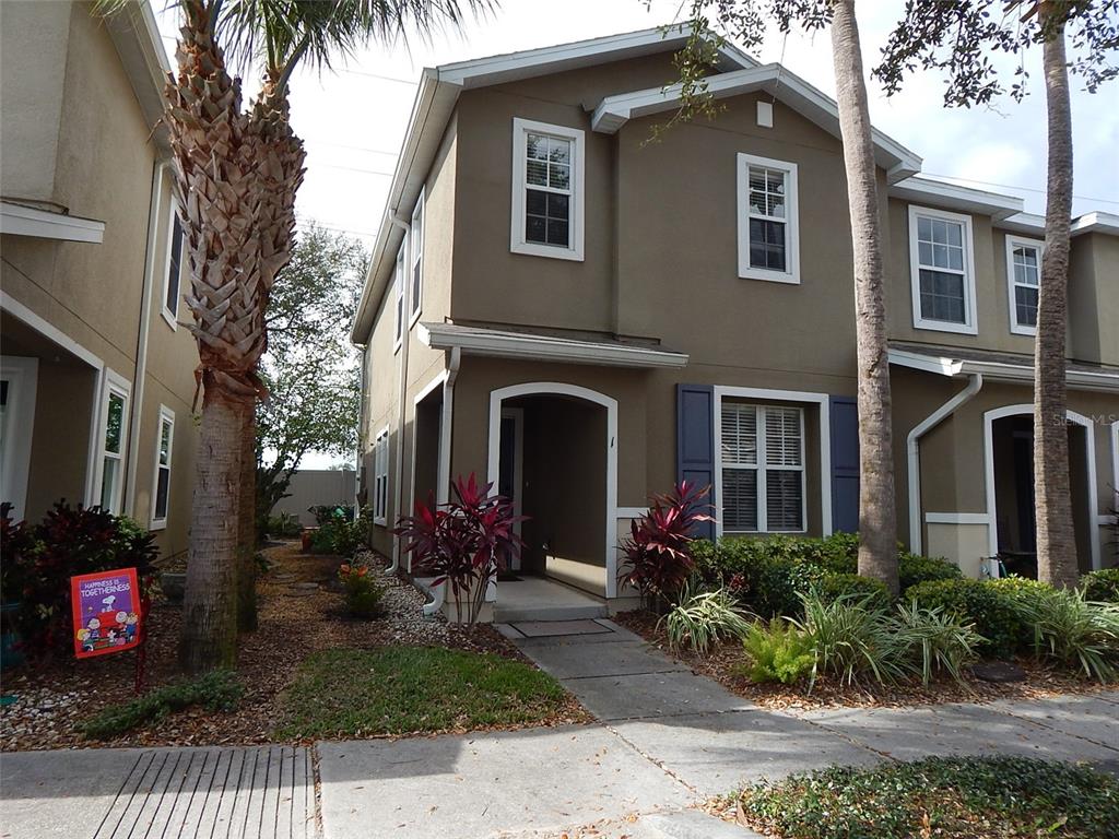 A two-story tan townhouse with a front walkway, landscaping, and a palm tree — 2537 HARN BOULEVARD UNIT 1, CLEARWATER, FL