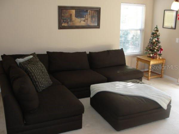 A living room features a large brown sectional sofa with an ottoman and a Christmas tree — 2537 HARN BOULEVARD UNIT 1, CLEARWATER, FL