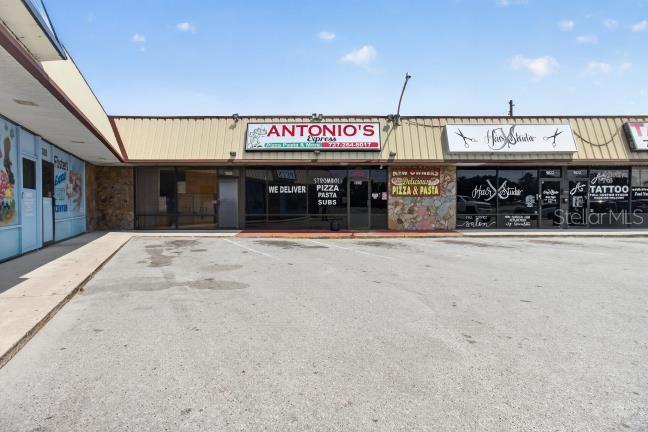 A strip mall exterior features Antonio's Express, a hair studio, and a tattoo shop — 9824 US HWY 19 HIGHWAY, PORT RICHEY, FL