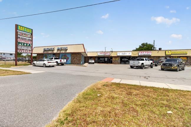 A strip mall features several storefronts, including an exotic pet shop and a tattoo parlor — 9824 US HWY 19 HIGHWAY, PORT RICHEY, FL