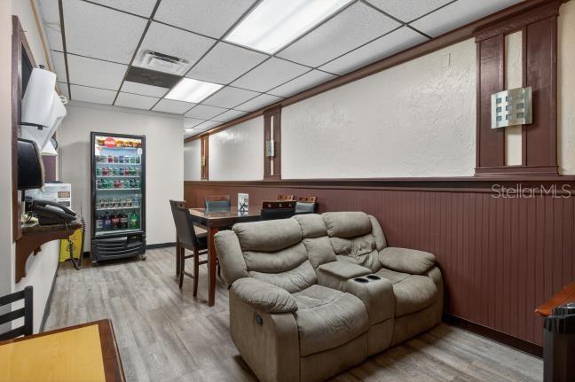 A room with a gray loveseat, a dining table, and a glass-front beverage refrigerator — 9824 US HWY 19 HIGHWAY, PORT RICHEY, FL