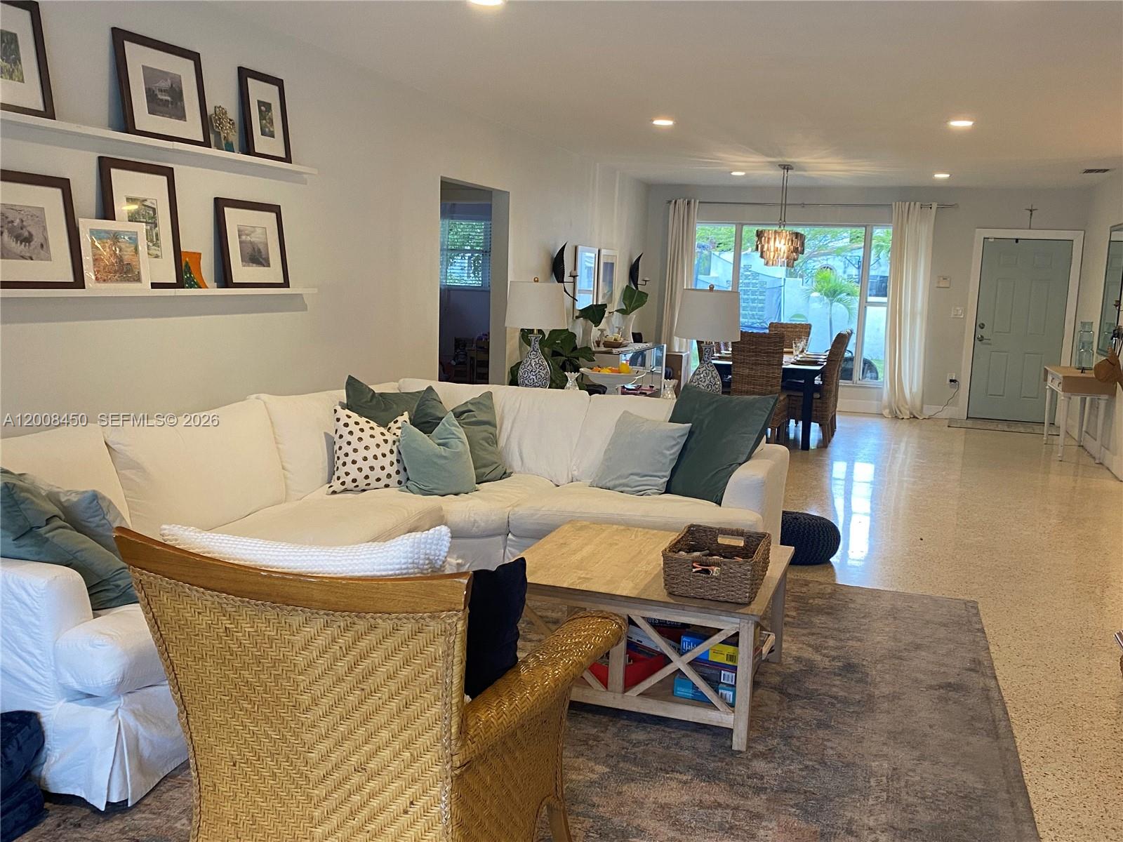 A living room features a white sectional sofa, a wicker chair, and a dining area — 3485 N Meridian Ave, Miami Beach FL 33140, MIAMI BEACH, FL