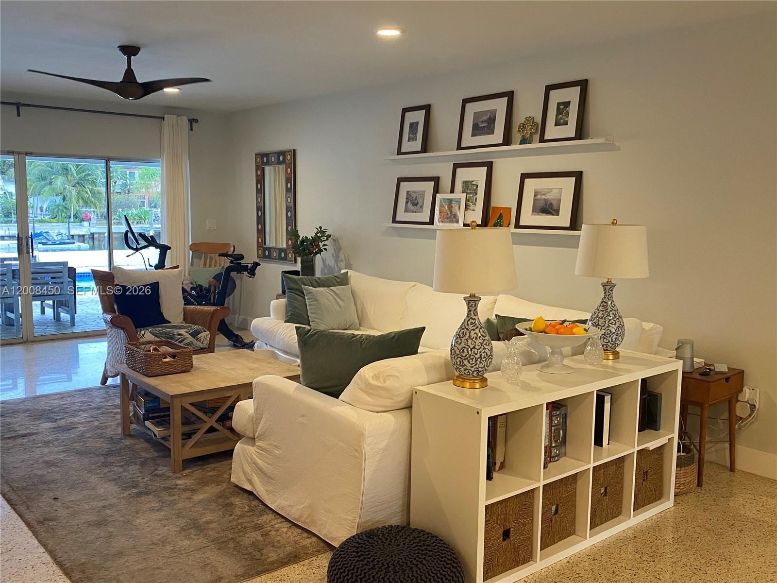 A living room features a white sectional sofa, a cube storage unit, and a sliding door — 3485 N Meridian Ave, Miami Beach FL 33140, MIAMI BEACH, FL