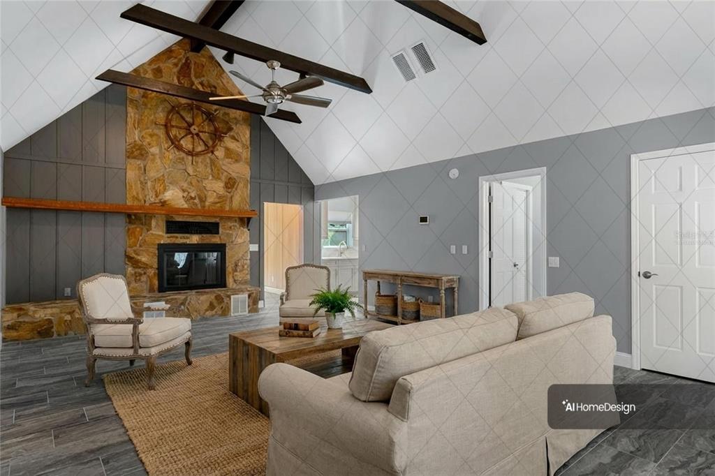 This living room features a stone fireplace, vaulted ceilings with exposed beams, and gray walls — 11870 W RIVERHAVEN DRIVE, HOMOSASSA, FL