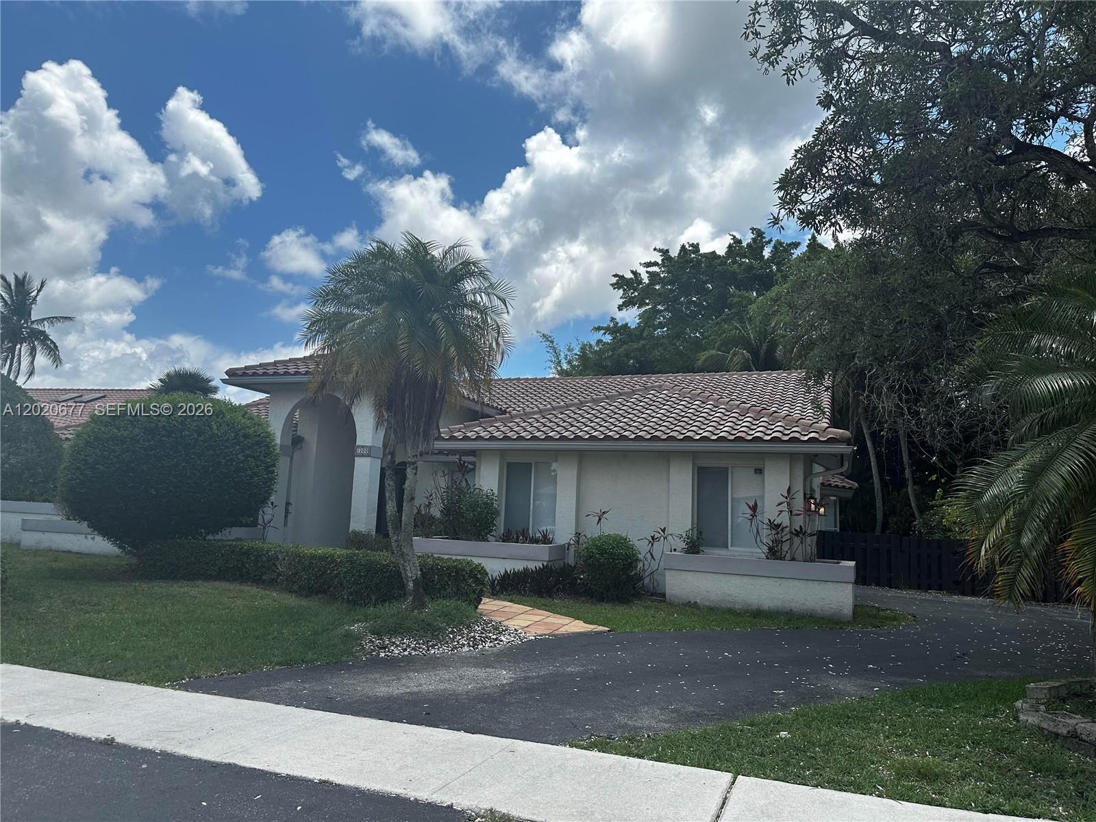 A single-story house with a tiled roof, arched entryway, and palm trees in the yard — 1200 NW 101st Ave, Plantation FL 33322, PLANTATION, FL