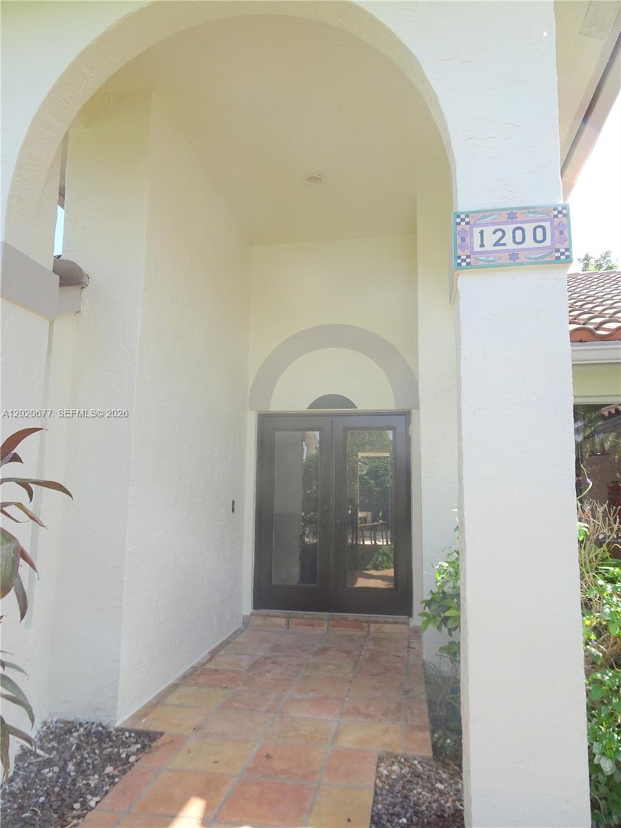 The exterior entrance features a tiled walkway, arched entryway, and double glass doors — 1200 NW 101st Ave, Plantation FL 33322, PLANTATION, FL