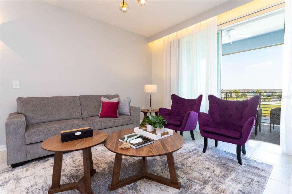 A living room features a grey sofa, two purple armchairs, and two round wooden tables — 3161 PARADOX CIRCLE UNIT 304, KISSIMMEE, FL