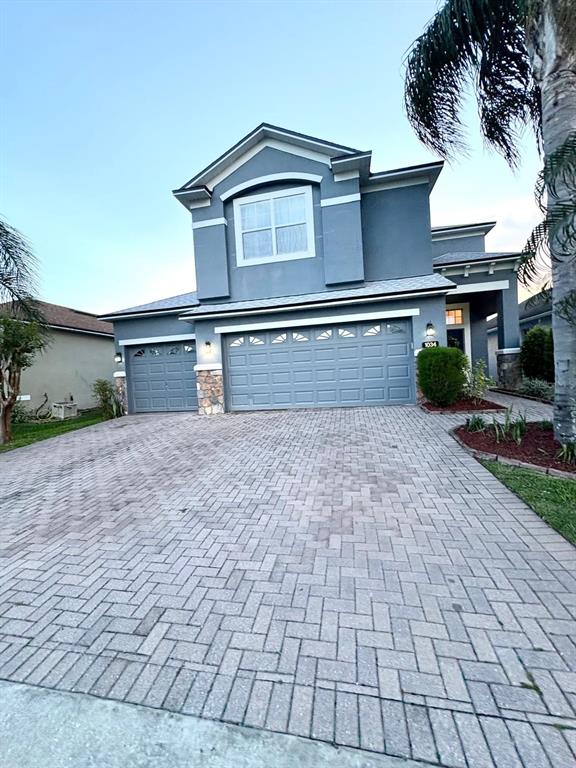 A two-story house with a gray exterior, a two-car garage, and a paved driveway — 1034 BELLA VIDA BOULEVARD, ORLANDO, FL