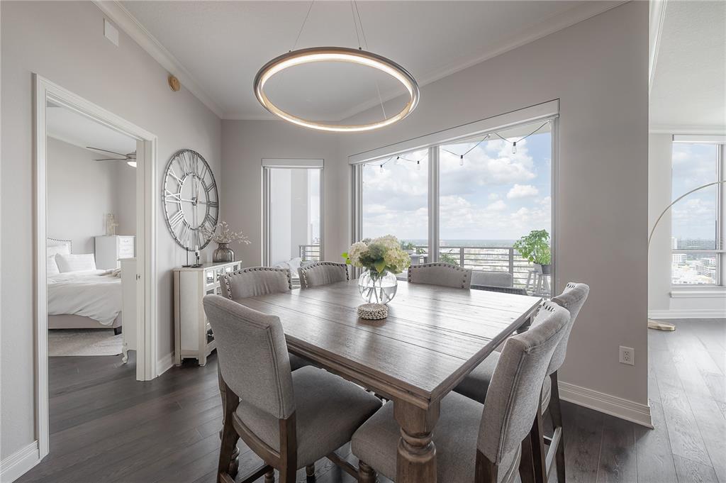 A dining room features a wooden table, gray upholstered chairs, and a circular pendant light — 449 S 12TH STREET UNIT 2501, TAMPA, FL